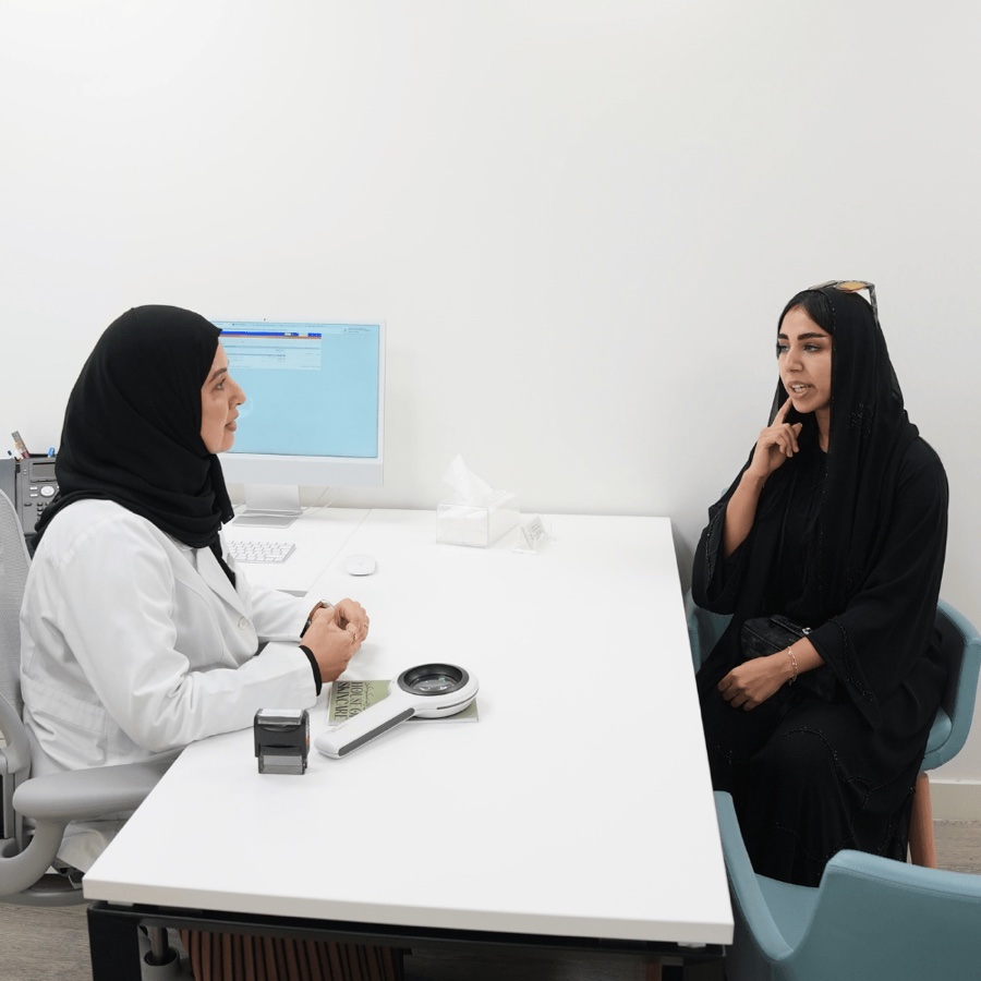 Dr. Khadija Al-Zaabi listening to a patient during dermatology consultation at Yas Island